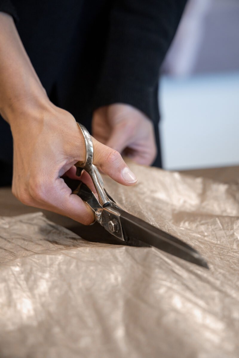 cutting gold cotton with large scissors